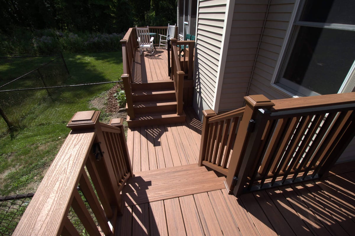 Exterior view of remodeled composite deck and stairs by Odd Fellows Contracting in Haslett, MI
