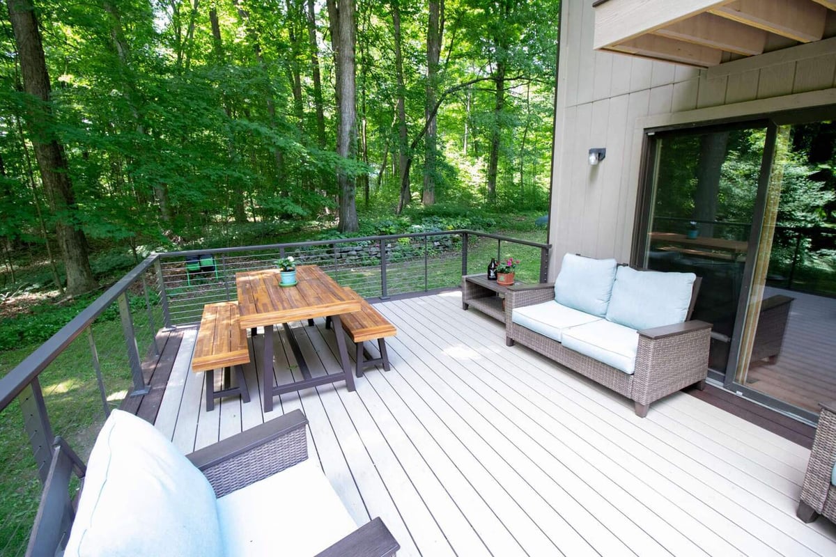 Composite backyard deck with outdoor seating area from deck remodel by Odd Fellows Contracting in Mason, MI