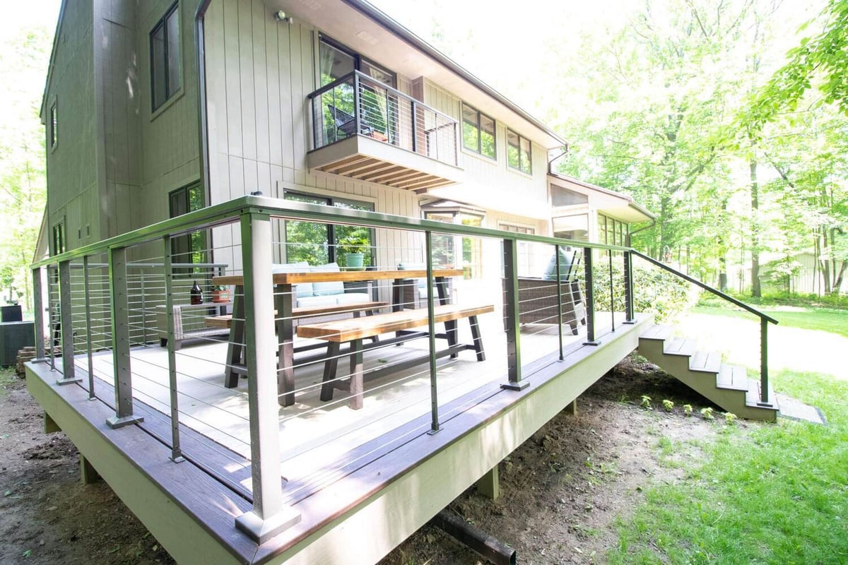 Deck remodel featuring composite decking and modern outdoor furniture by Odd Fellows Contracting in Mason, MI