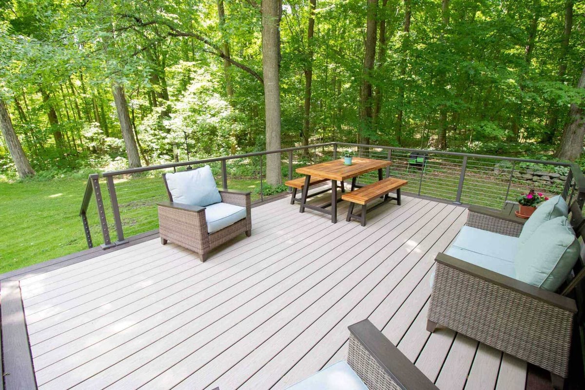 Elevated composite deck with outdoor furniture by Odd Fellows Contracting in Mason, MI