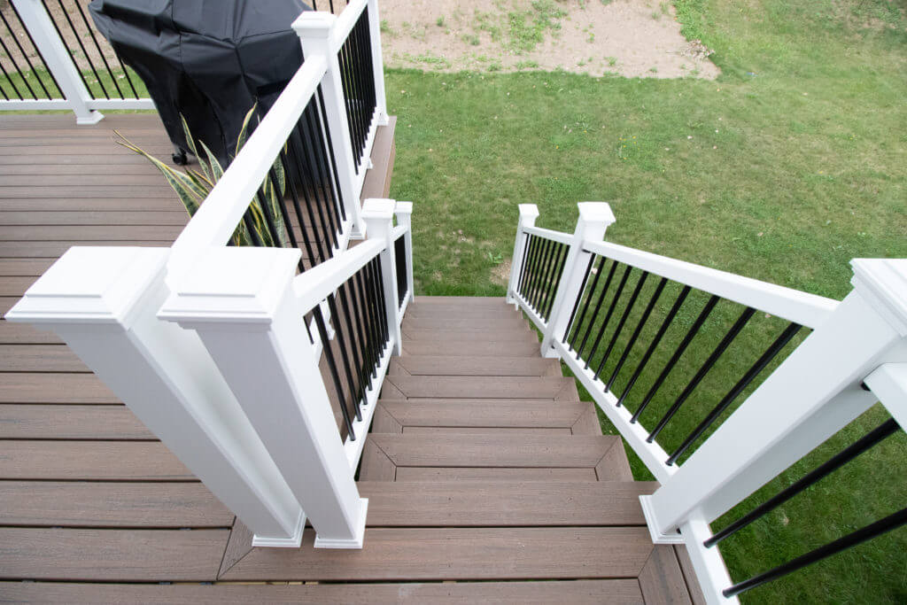 deck staircase with composite steps and modern railing system by Odd Fellows Contracting in Williamston, MI