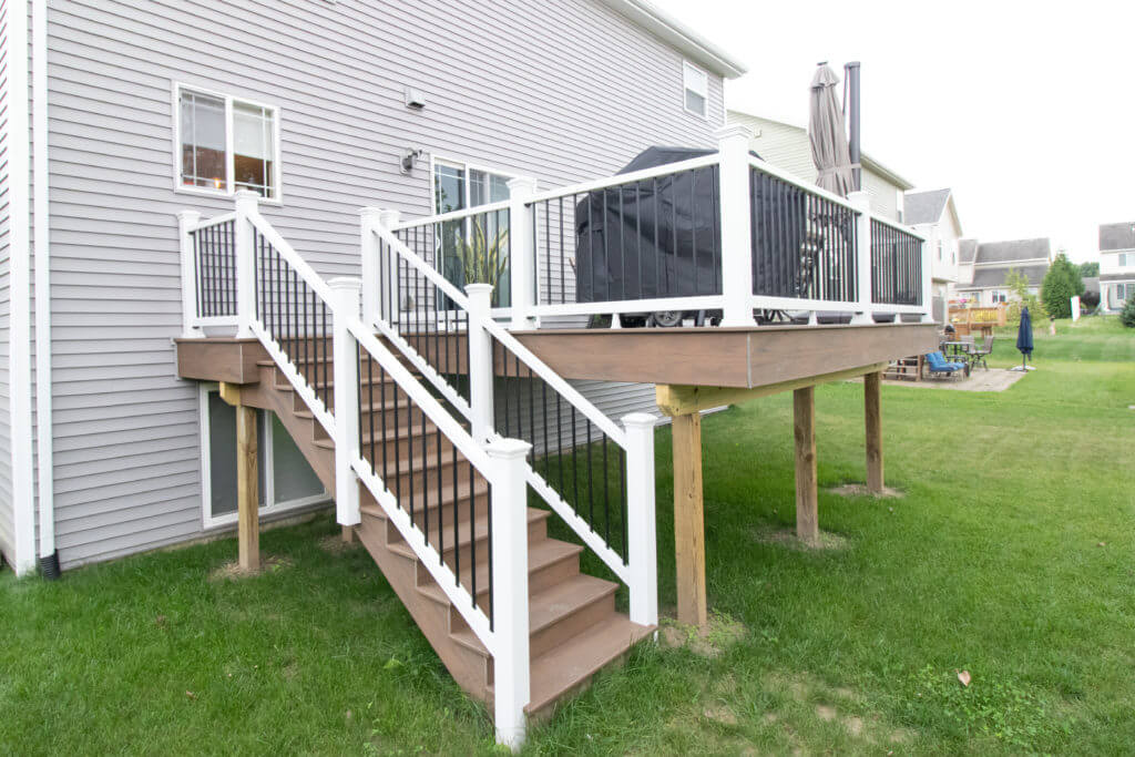 new elevated deck with staircase and composite decking built by Odd Fellows Contracting in Williamston, MI
