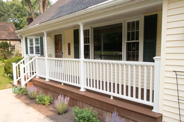 Updated front porch with white railing and composite decking in East Lansing MI by Odd Fellows Contracting