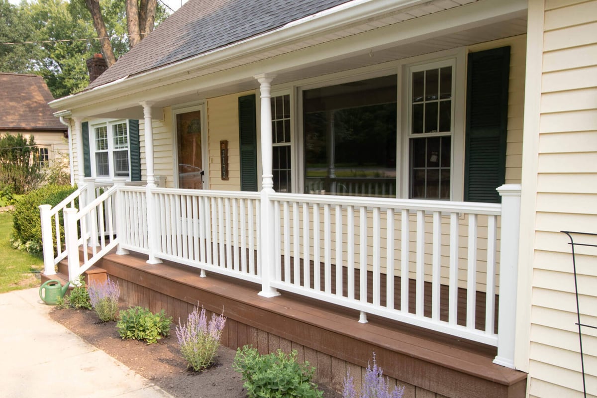 updated front porch with white railing and composite decking by Odd Fellows Contracting in East Lansing MI