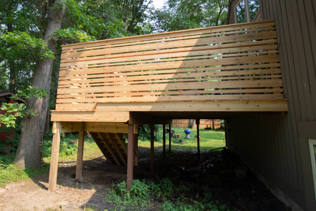 backyard view of cedar deck remodel with privacy railing by Odd Fellows Contracting Haslett MI