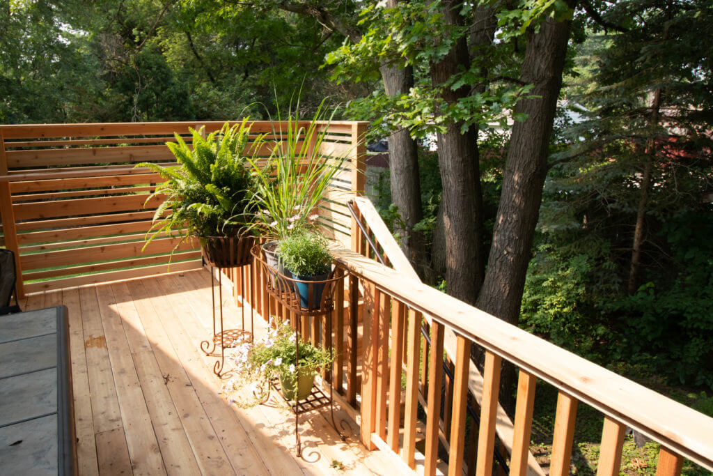 finished cedar deck corner with plant stands and privacy railing by Odd Fellows Contracting Haslett MI