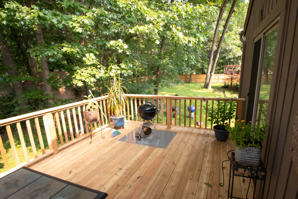 finished cedar deck space with railing overlooking backyard by Odd Fellows Contracting Haslett MI