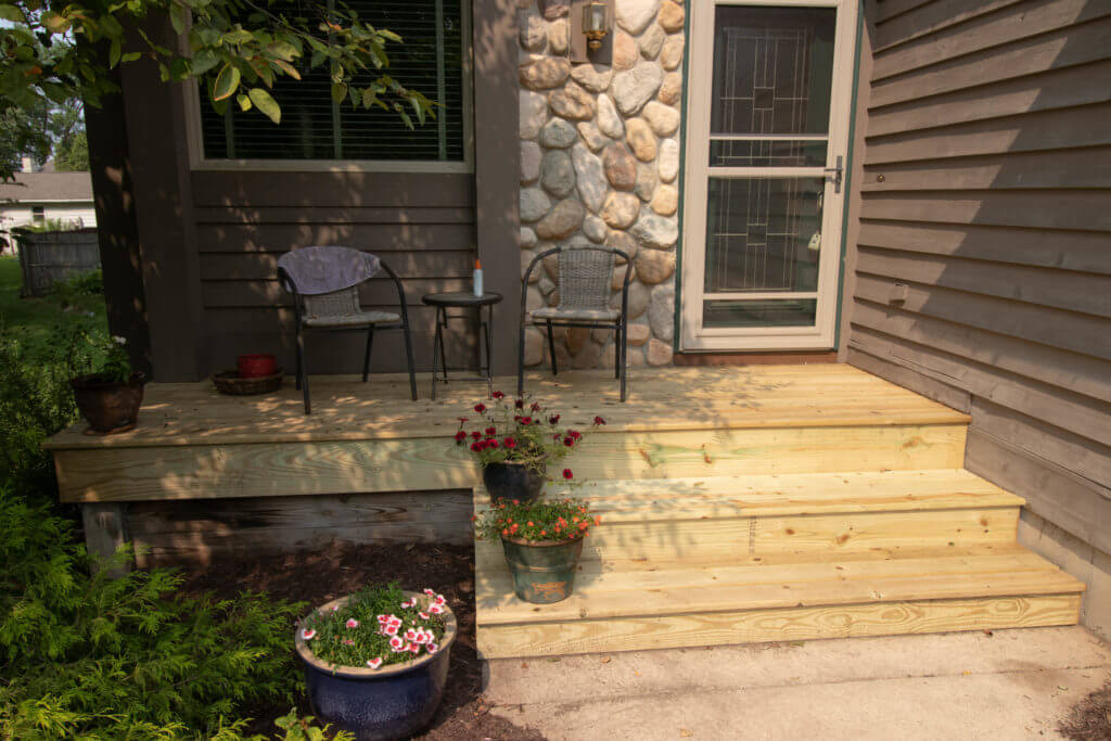 small entry deck with steps built in cedar by Odd Fellows Contracting in Haslett MI