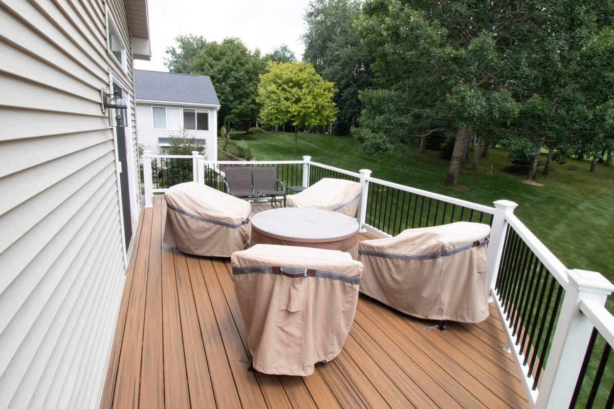deck remodel staircase with composite decking boards and white railing posts by Odd Fellows Contracting in Williamston, MI