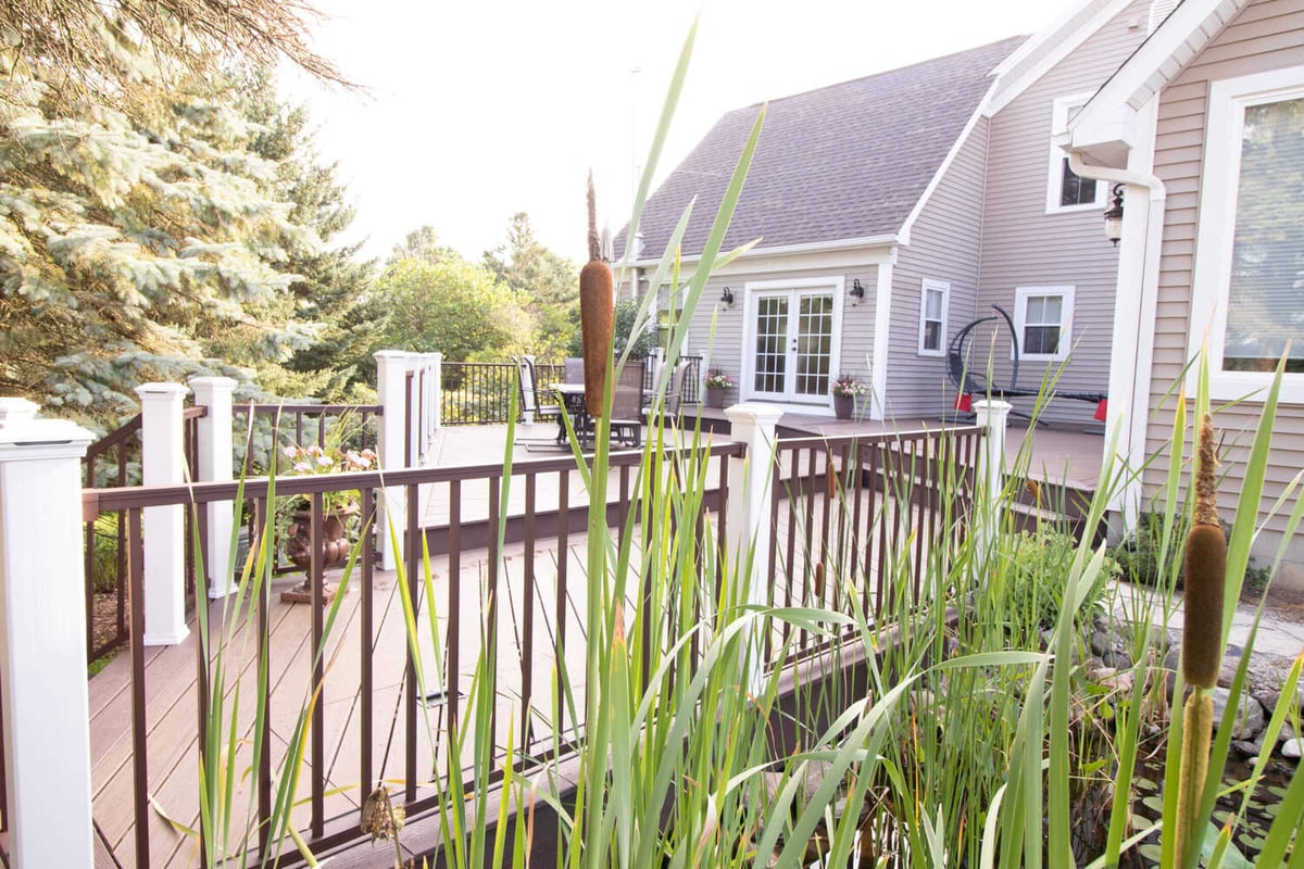 deck overlooking pond by Odd Fellows Contracting in Williamston MI with landscaping and water plants