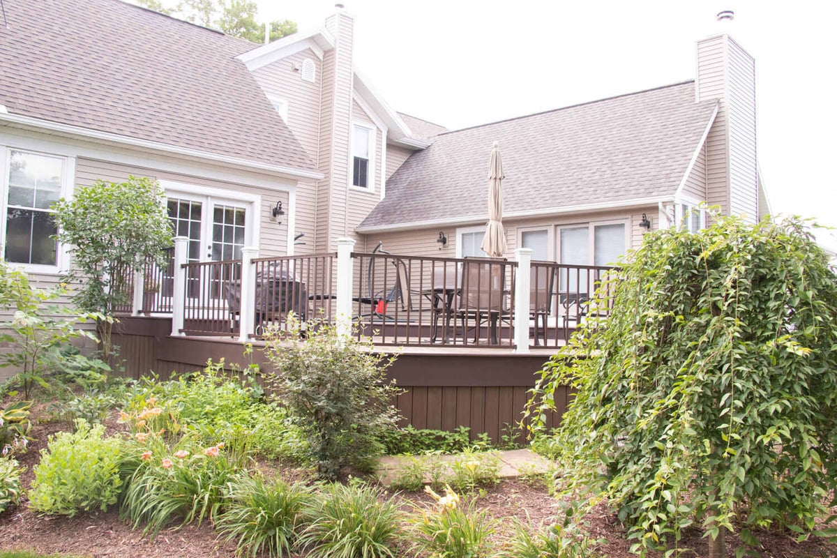 elevated deck by Odd Fellows Contracting in Williamston MI with railing and backyard garden view