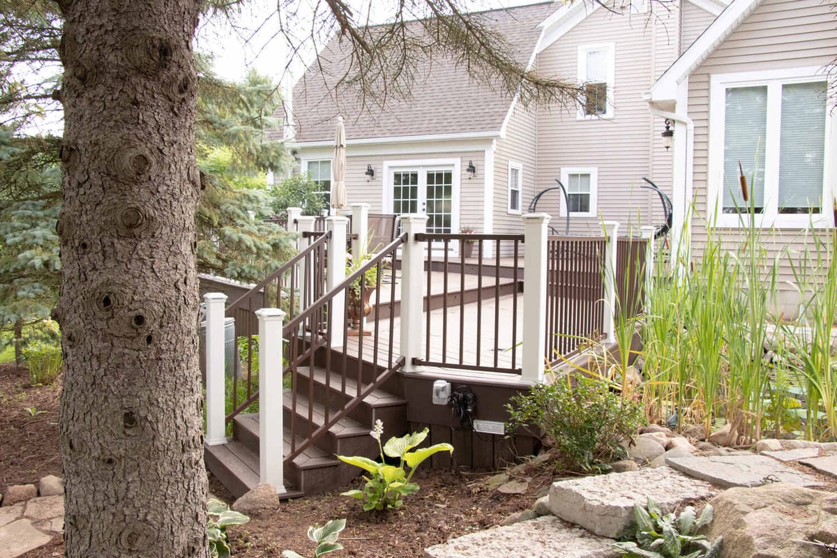 outdoor deck access by Odd Fellows Contracting in Williamston MI with steps and surrounding greenery