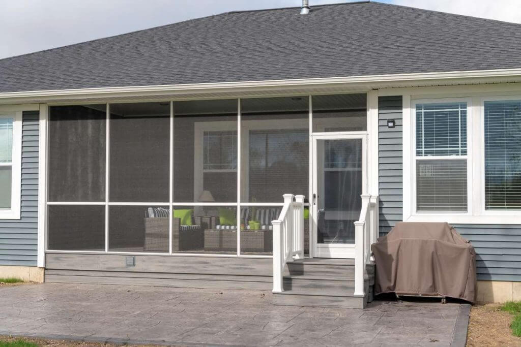 backyard screened porch outdoor living space with seating by Odd Fellows Contracting in Okemos MI