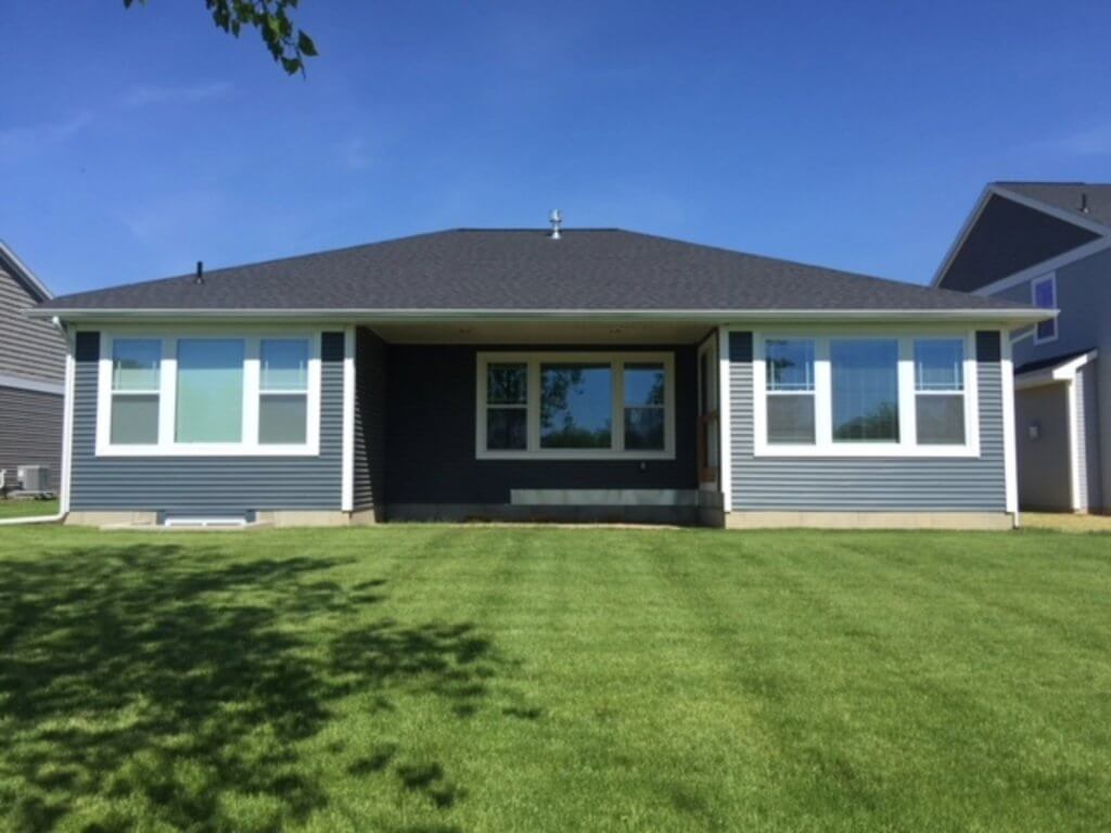 backyard view of house before screened porch and patio project by Odd Fellows Contracting in Okemos MI