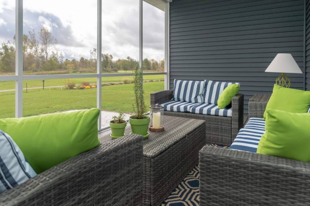 comfortable outdoor living space seating inside screened porch by Odd Fellows Contracting in Okemos MI