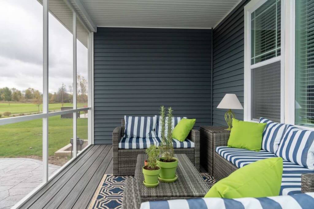 finished screened porch with wicker furniture and accent pillows by Odd Fellows Contracting in Okemos MI