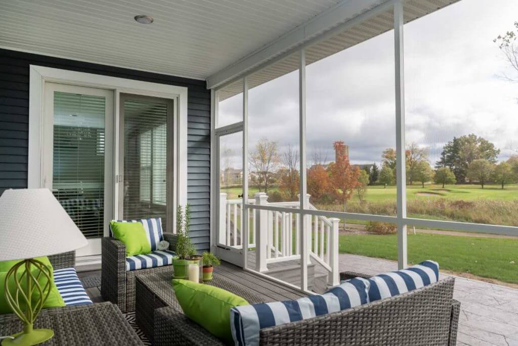 relaxing screened porch with comfortable furniture by Odd Fellows Contracting in Okemos MI