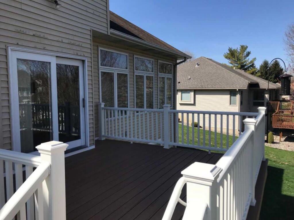 backyard deck with composite flooring and railing by Odd Fellows Contracting in Holt MI