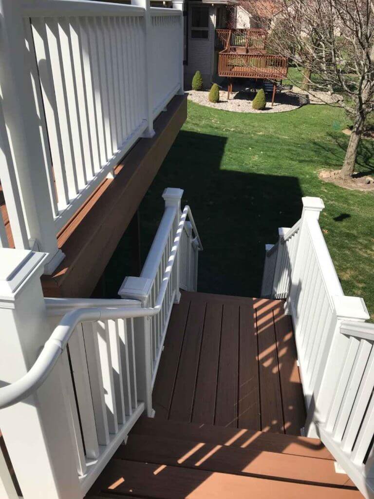 composite deck staircase leading to backyard by Odd Fellows Contracting in Holt MI