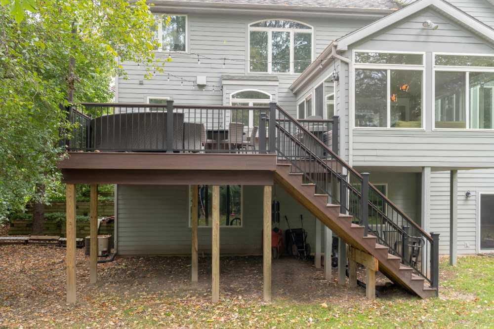 Finished Trex composite deck with black railing and stairs built by Odd Fellows Contracting in Okemos MI