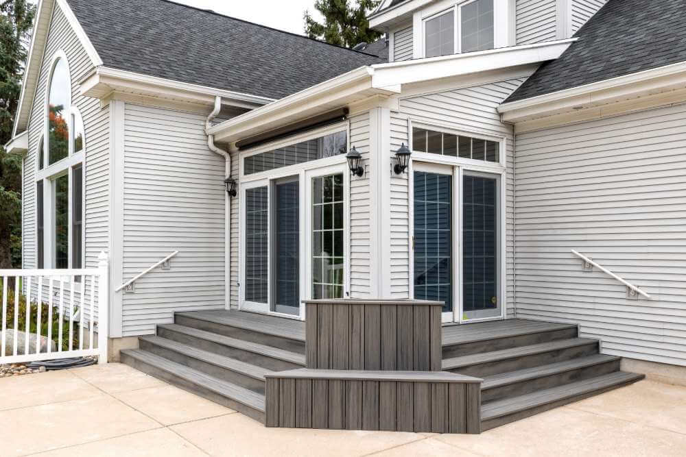 Composite deck steps and patio transition built by Odd Fellows Contracting in Williamston Michigan