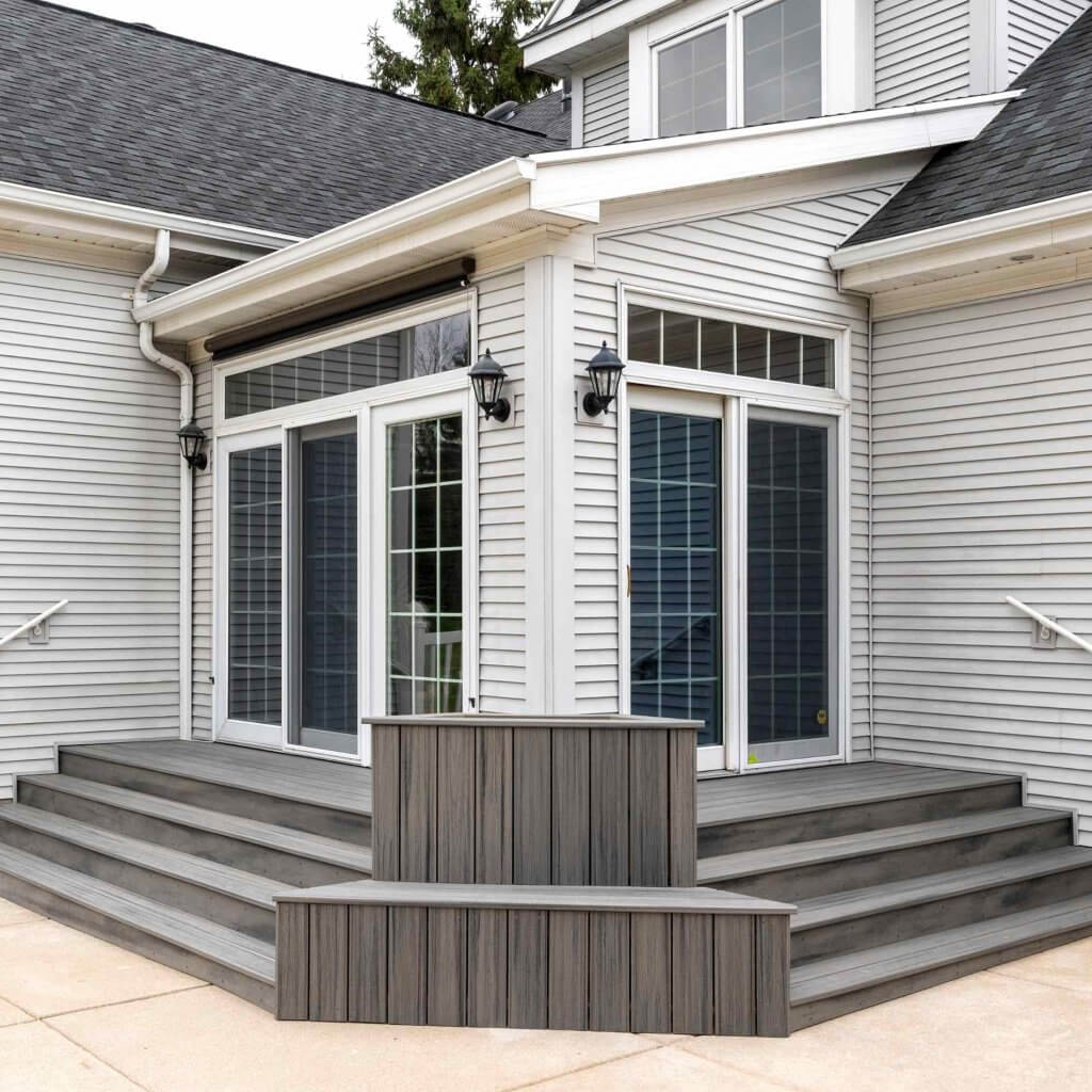 Finished outdoor living space with composite deck stairs by Odd Fellows Contracting in Williamston MI