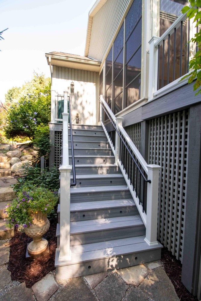 outdoor deck stair renovation with modern railing and composite boards by Odd Fellows Contracting in Williamston MI