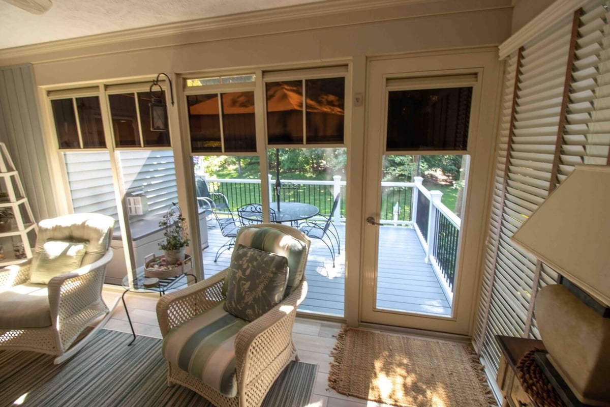 sunroom seating area with access to newly remodeled composite deck by Odd Fellows Contracting in Williamston MI