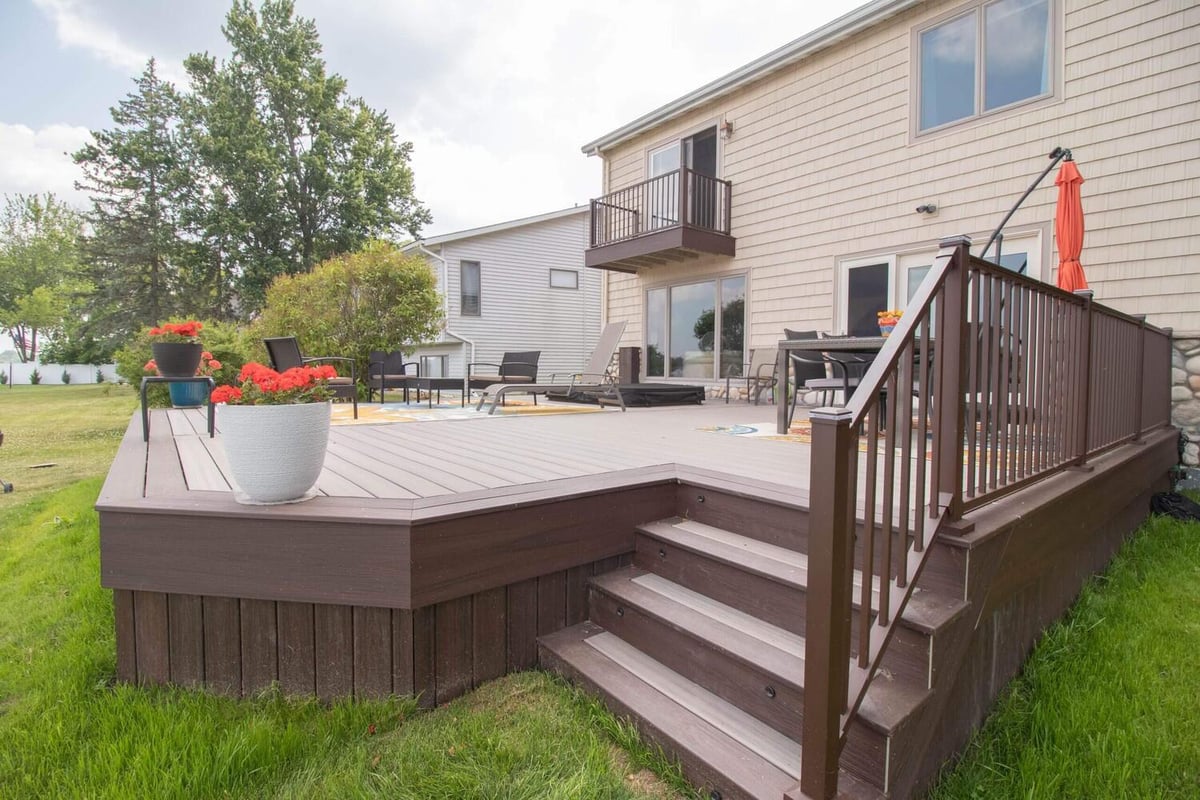 backyard deck renovation featuring composite decking and stair railing by Odd Fellows Contracting in Haslett Lake MI