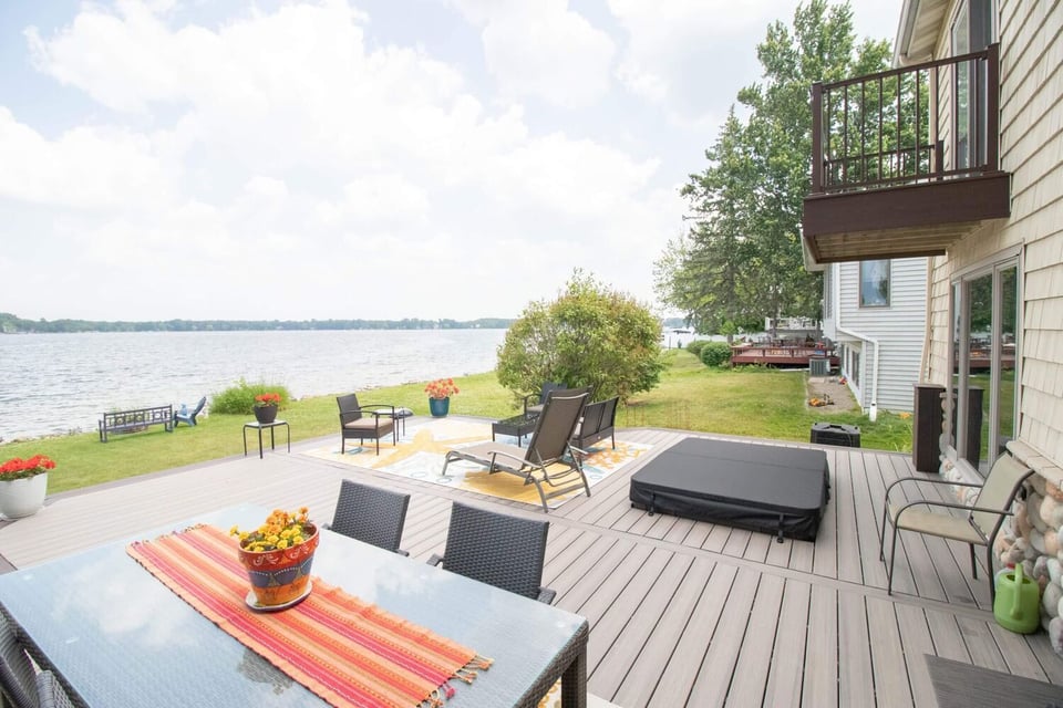 finished lakefront deck renovation with outdoor seating and composite boards by Odd Fellows Contracting in Haslett Lake MI