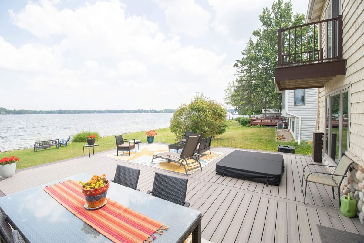 finished lakefront deck renovation with outdoor seating and composite boards by Odd Fellows Contracting in Haslett Lake MI