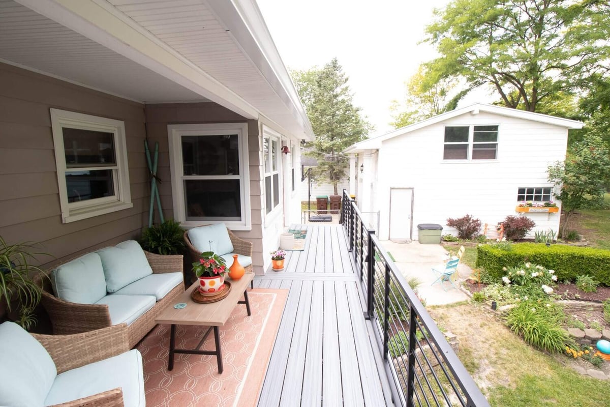 finished backyard deck remodel with seating space and railing by Odd Fellows Contracting in Lansing MI