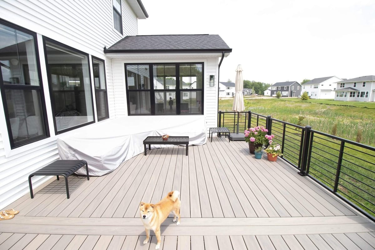 finished backyard deck renovation with modern railing and stairs by Odd Fellows Contracting in Haslett, MI