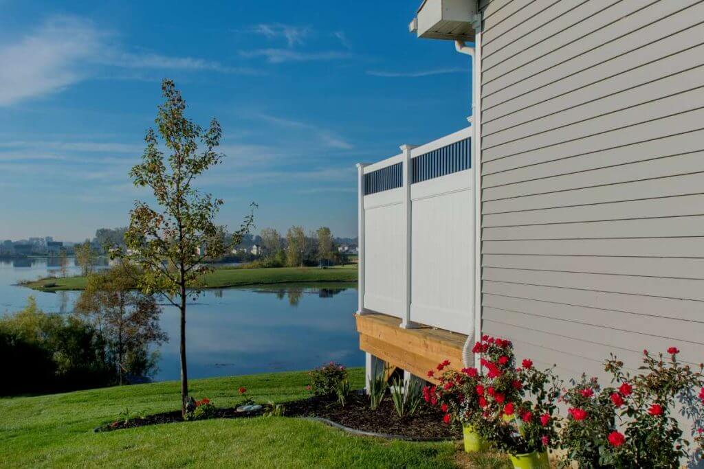 Backyard deck with privacy panel and lake view in Mason MI by Odd Fellows Contracting
