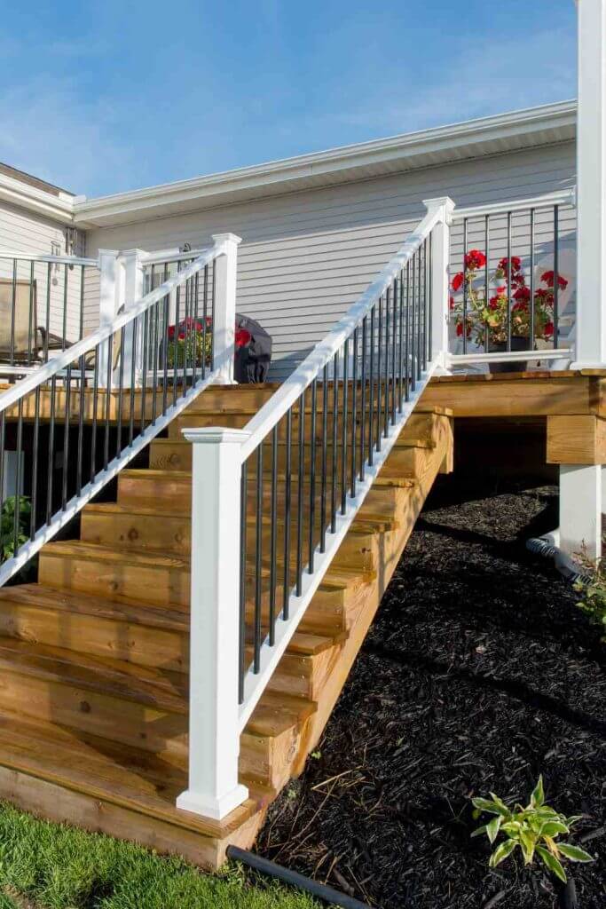 Deck stairs with white posts and black balusters in Mason MI by Odd Fellows Contracting