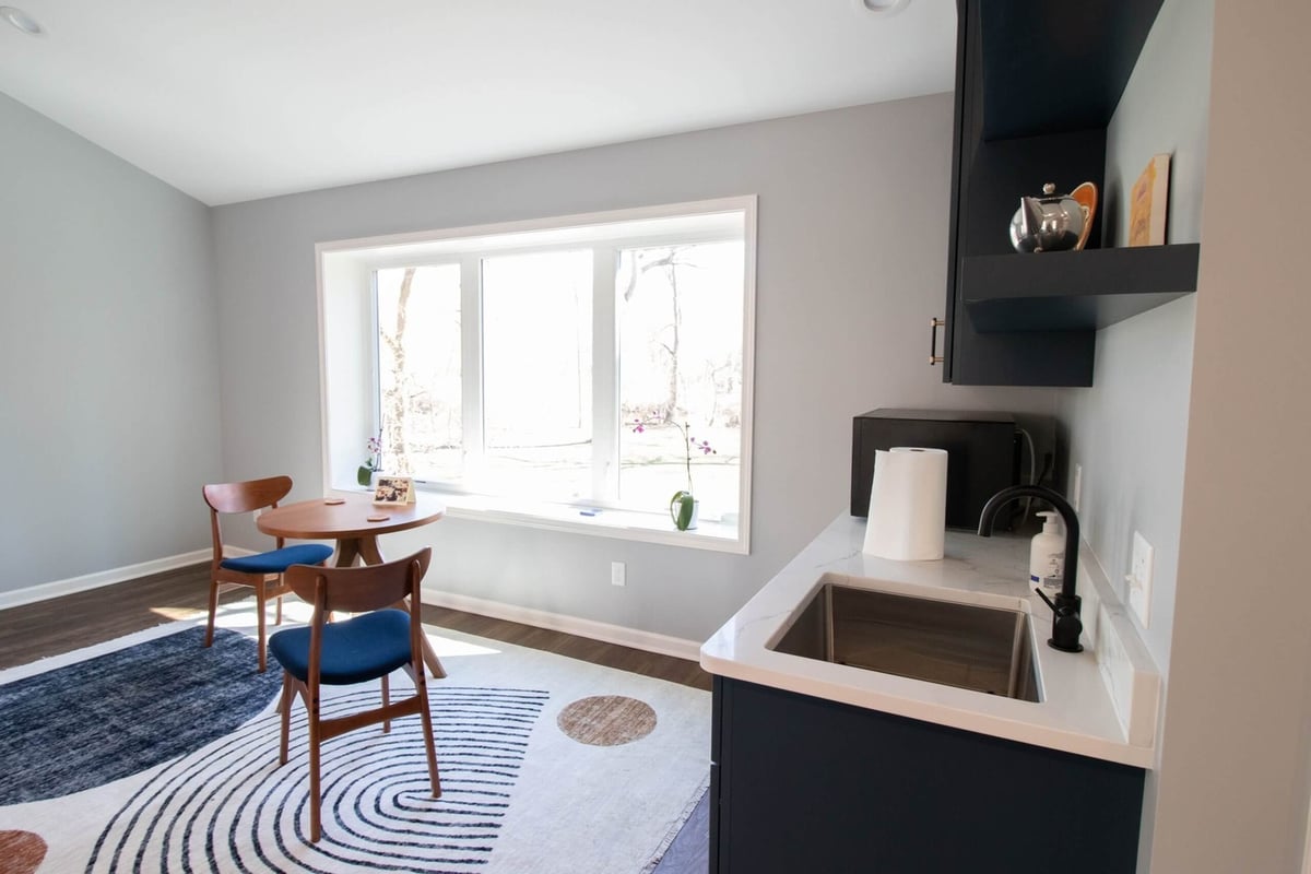 converted garage living area with large windows and seating by Odd Fellows Contracting in Okemos, MI