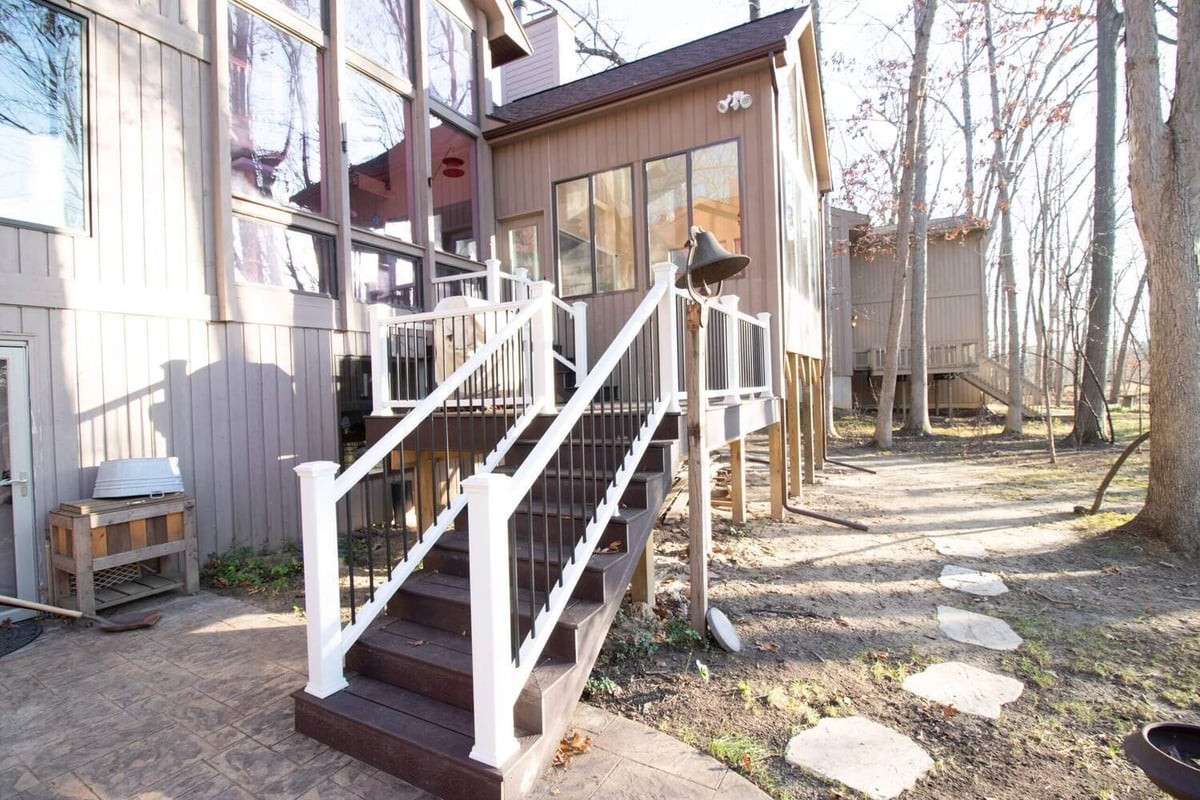exterior deck stairs with white railing built for four seasons room by Odd Fellows Contracting in Haslett MI