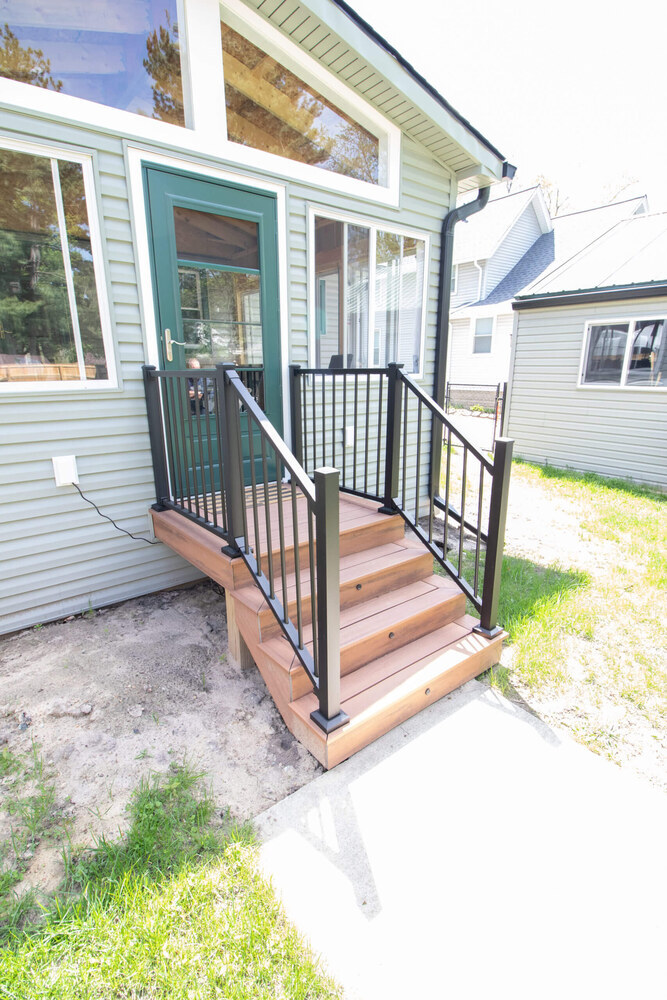 exterior view of completed three seasons room addition with new steps by Odd Fellows Contracting in Holt, MI