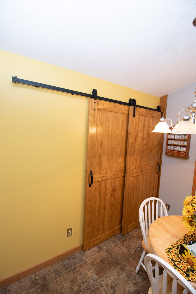 Garage laundry addition featuring custom wood barn doors by Odd Fellows Contracting in Williamston, MI