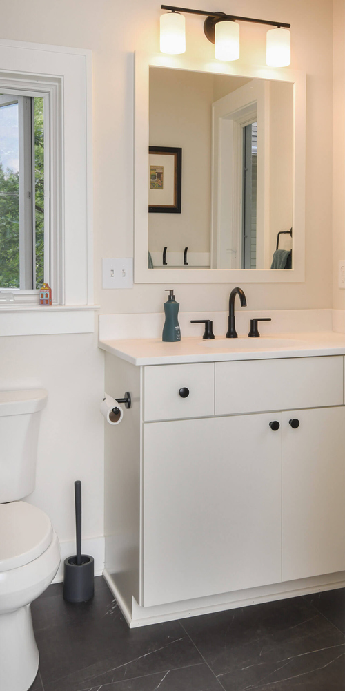 Bathroom vanity and mirror with modern lighting from home addition by Odd Fellows Contracting in Mason, MI