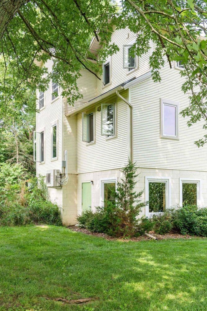 Rear exterior of completed home addition by Odd Fellows Contracting in Mason, MI showing expanded structure and landscaping