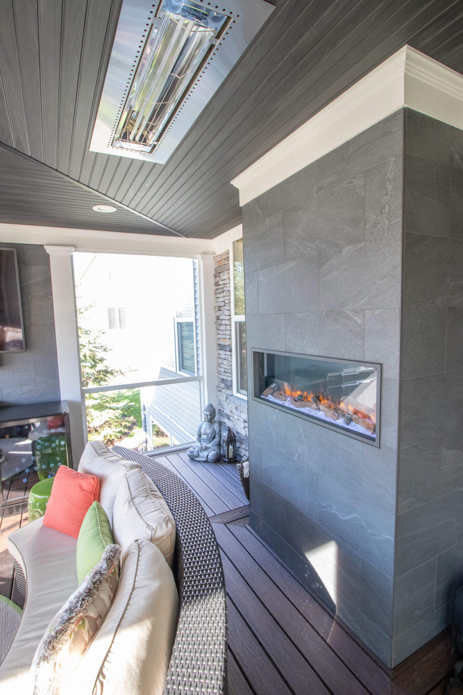 enclosed porch ceiling design with outdoor heating and fireplace by Odd Fellows Contracting in Okemos MI