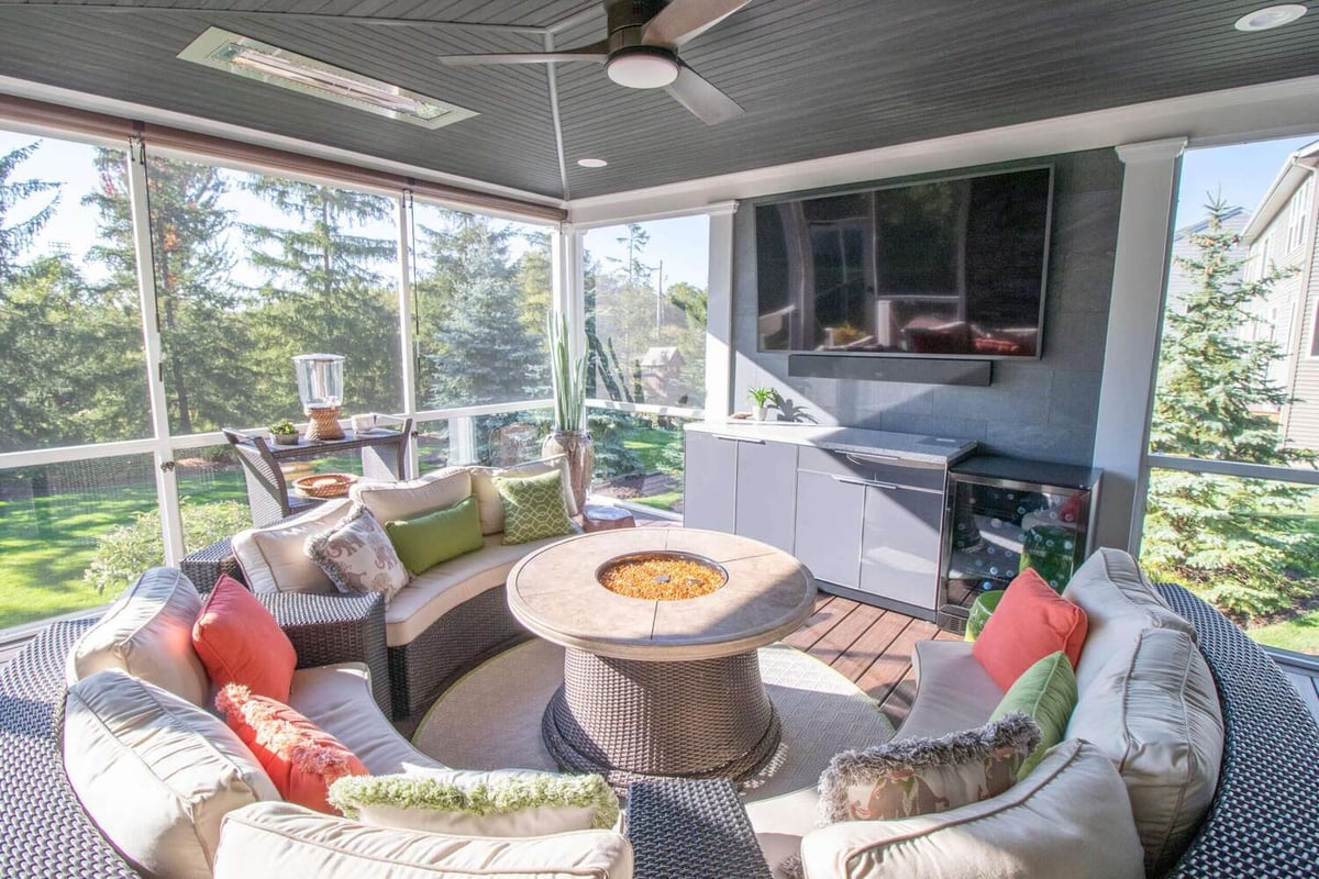 interior three season room with seating area and fire table by Odd Fellows Contracting Okemos MI