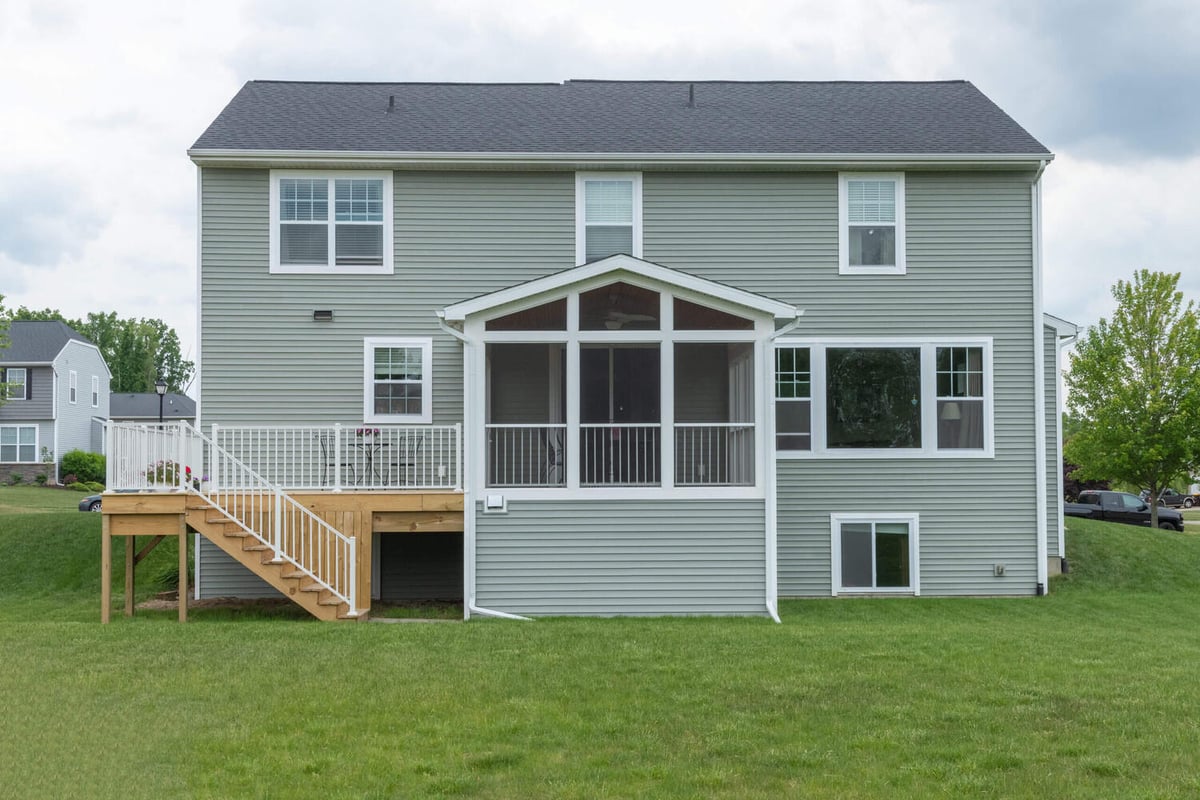 full backyard view of three season room and deck addition by Odd Fellows Contracting in Lansing MI