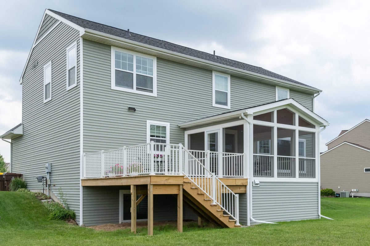 screened porch and elevated deck attached to two story home by Odd Fellows Contracting Lansing MI