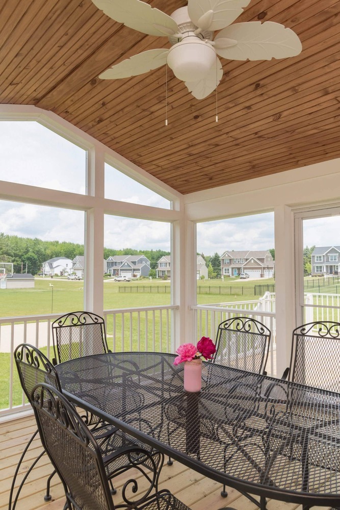 screened porch dining area with large windows and wood ceiling by Odd Fellows Contracting Lansing MI