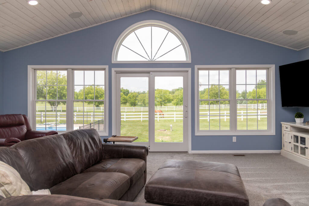 family room addition with large arched window and patio doors by Odd Fellows Contracting in Williamston MI