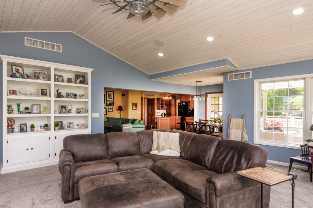spacious living room addition with vaulted ceiling and built in shelving by Odd Fellows Contracting in Williamston MI