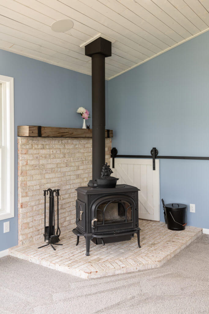 wood stove and brick fireplace detail in family room addition by Odd Fellows Contracting in Williamston MI