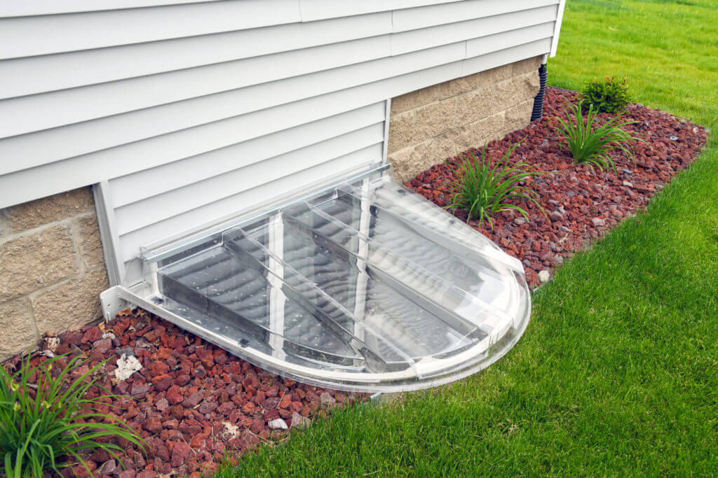 clear window well cover and landscaping detail on home addition by Odd Fellows Contracting East Lansing MI